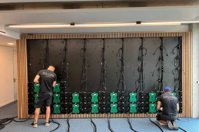 Techniker von PRO VIDEO montieren erste LED-Module und schließen Daten- und Stromkabel an – Medientechnikprojekt an der Universität Bremen