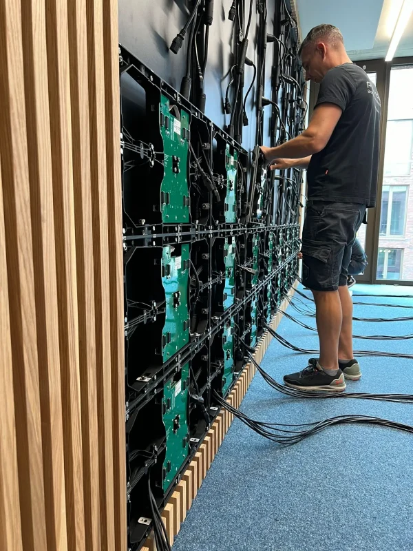 Ein Medientechniker von pro video GmbH bei der Installation einer LED-Wand mit 0,9 mm Pixelpitch – professionelle Umsetzung modernster Medientechnik.