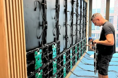 Techniker von PRO VIDEO bei der LED-Wand-Montage an der Universität Bremen