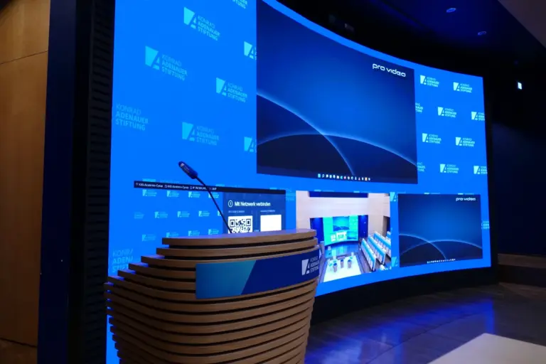Finale Ansicht der konkaven LED-Wand (LED-Video-Wand) mit Rednerpult im Hauptstadtforum der Konrad-Adenauer-Stiftung e.V.(KAS), realisiert von PRO VIDEO GmbH